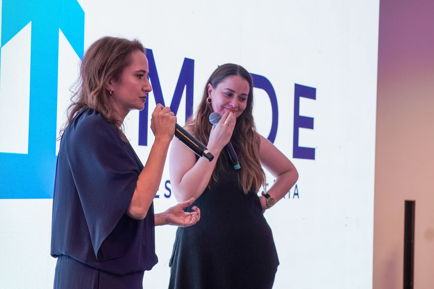 Convidadas participando de uma conversa no palco